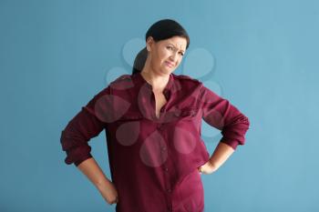 Portrait of displeased mature woman on color background�