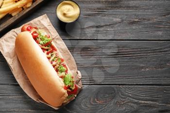 Tasty hot dog on wooden table�