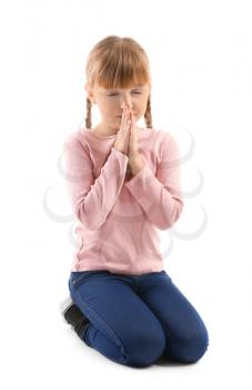 Little girl praying on white background�