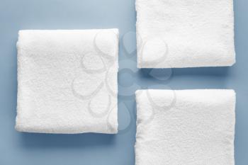 Clean soft towels on color background�