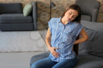 Young pregnant woman suffering from pain at home�