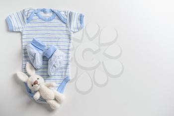 Cute baby clothes and toy on white background�