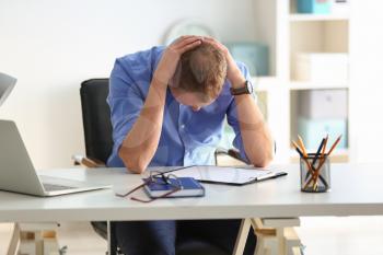 Man having panic attack at workplace in office�