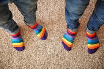 Gay couple with colorful socks standing on carpet, top view�