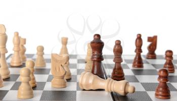 Chess pieces on game board against white background�