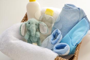 Baby clothes, cosmetics and toy in basket�