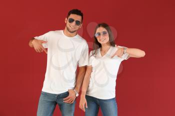 Young man and woman in stylish t-shirts on color background�