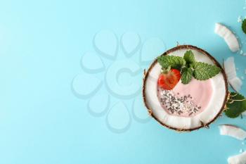 Coconut bowl with pink yogurt on color background�
