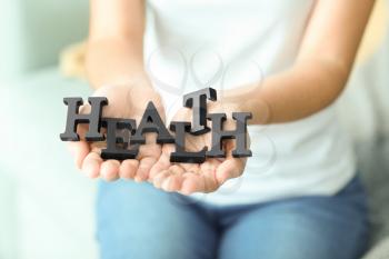 Woman holding black letters, closeup. Health care concept�