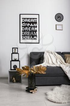 Stylish interior of room with comfortable sofa and golden decor�