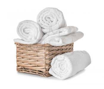 Wicker basket with clean soft towels on white background�