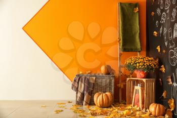 Beautiful autumn composition with pumpkins and leaves near color wall�