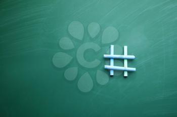 Hashtag sign made of chalks on color background�