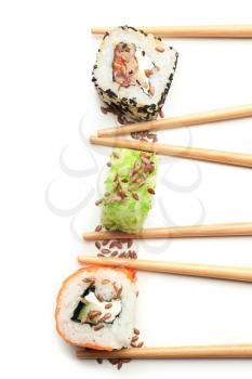 Tasty sushi rolls with chopsticks on white background�