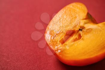 Half of juicy persimmon on color background. Erotic concept�