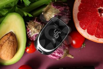 Digital glucometer with healthy food on color background. Diabetes diet�