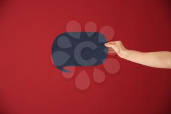 Male hand with speech bubble on color background�