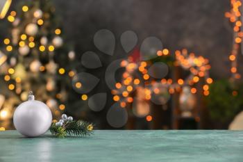 Decorations on color table against blurred Christmas interior�