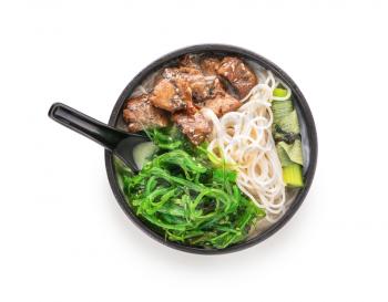 Tasty Chinese soup in bowl on white background�