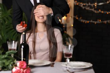 Young man proposing to his beloved in restaurant�