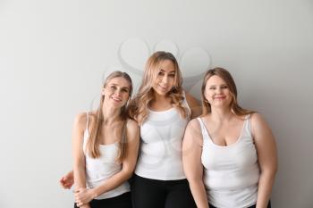 Beautiful young women on light background. Concept of body positivity�