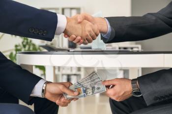 Two businessmen with bribe in office. Concept of corruption�