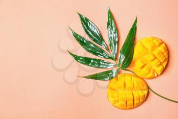 Green tropical leaves and mango on color background�