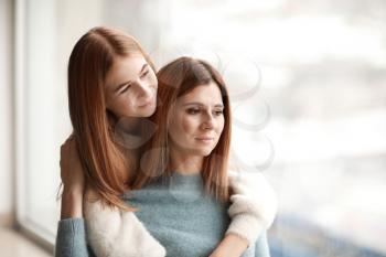 Portrait of happy mother and daughter near window�