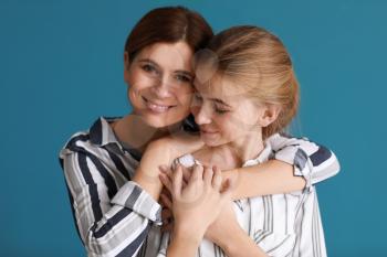 Portrait of happy mother and daughter on color background�