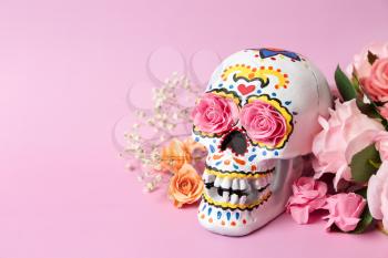 Painted human skull with flowers for Mexico's Day of the Dead on color background�