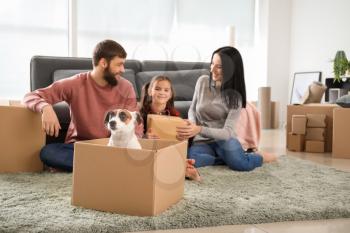 Cute dog in cardboard box and happy family after moving into new house�