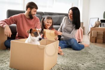 Cute dog in cardboard box and happy family after moving into new house�