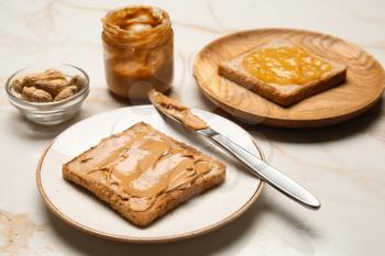 Toasted bread with tasty peanut butter on light table�
