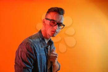 Toned portrait of handsome young man on color background�
