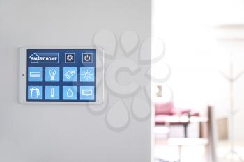 Tablet computer with smart home application on wall�