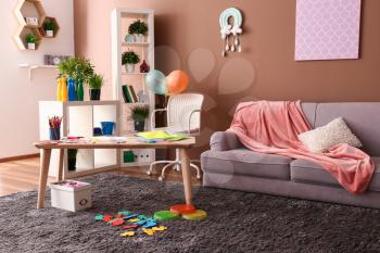 Stylish interior of kid room with wooden table�