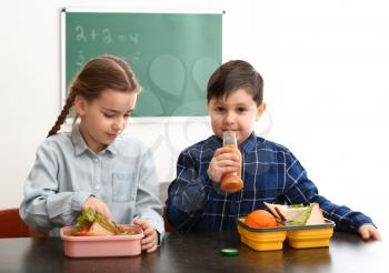 Little children having lunch in classroom�