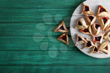 Tasty hamantaschen for Purim holiday on wooden table�