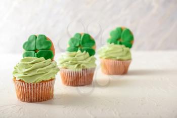 Tasty cupcakes for St. Patrick's Day celebration on white table�