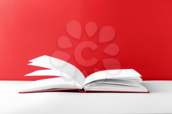 Book on table against color background�