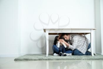 Family under table during earthquake indoors�