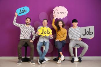 Young people holding speech bubbles with words JOB and CAREER indoors�