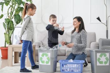 Family sorting garbage at home. Concept of recycling�