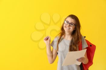 Happy girl with results of school test on color background�