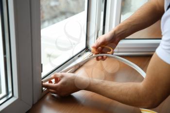 Young worker installing window in flat�