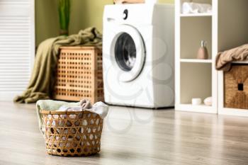 Basket with dirty laundry on floor in bathroom�