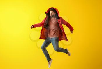 Fashionable jumping young man on color background�