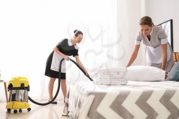Beautiful female housekeepers working in room�