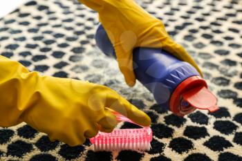Woman cleaning carpet�