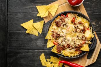 Tasty Mexican dish with nachos on table�